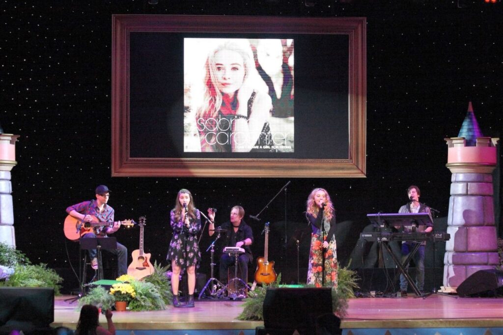 Sabrina performing live on stage during a music event at Disneyland
